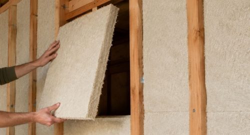 Aislamiento de cáñamo instalado en una estructura de madera para construcción sostenible y bioconstrucción.